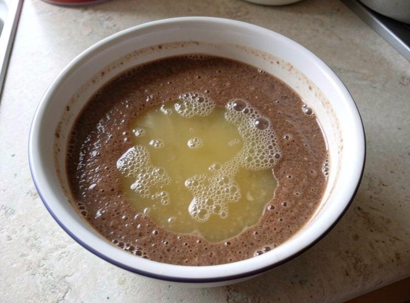 Bubbling fermenting teff batter with a layer of cloudy ersho liquid on top