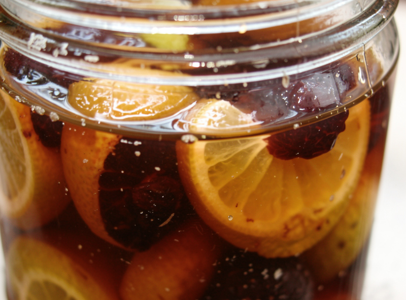 Salt-preserved limes that have turned dark and jammy inside a jar with deep amber brine